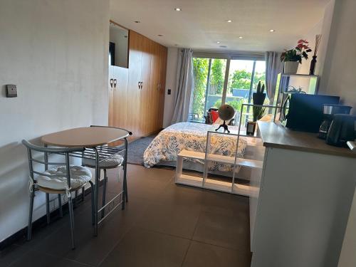 1 dormitorio con 1 cama, mesa y sillas en Studio Charmant&calme en Knokke-Heist