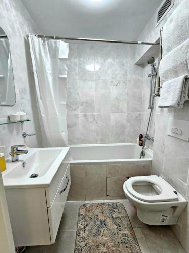 a bathroom with a white tub and a toilet and a sink at 153 Красивые Апартаменты ЖК Абая 130 in Almaty