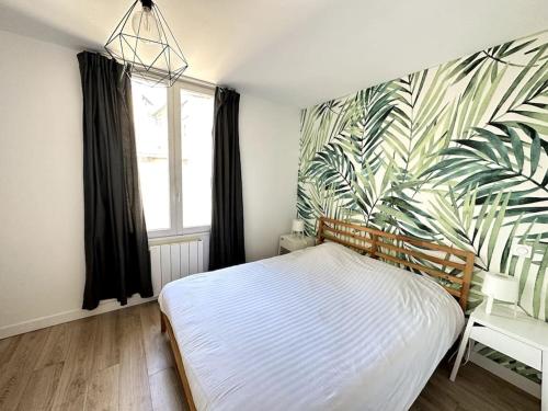 1 dormitorio con cama y papel pintado tropical en Le Forum - HYPER centre - PARKING, en Reims