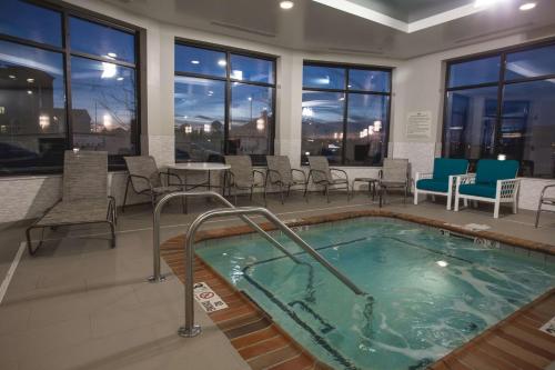 a hot tub in a room with chairs and tables at Hilton Garden Inn Bolingbrook I-55 in Bolingbrook