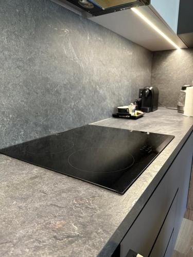 a kitchen counter with a black counter top at ALEKSANDRA 2 - CONCRETE in Kielce