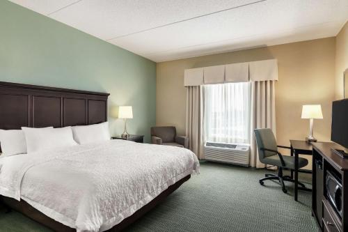 ein Hotelzimmer mit einem Bett, einem Schreibtisch und einem Fenster in der Unterkunft Hampton Inn & Suites Mount Joy/Lancaster West, Pa in Manheim