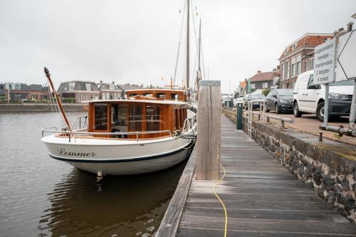 a boat is docked next to a dock at Huis aan de Haven in Lemmer