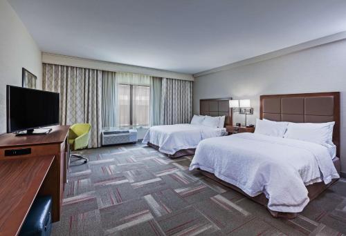 um quarto de hotel com duas camas e uma televisão de ecrã plano em Hampton Inn & Suites Claremore em Claremore