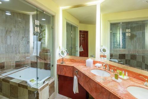 a bathroom with two sinks and a shower and a tub at Hilton San Luis Potosi in San Luis Potosí