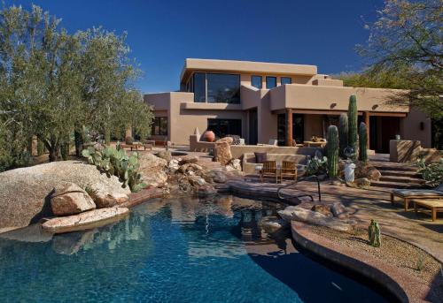 a house with a swimming pool in front of a house at Boulders Resort & Spa Scottsdale, Curio Collection by Hilton in Scottsdale
