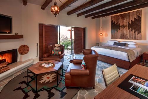 a bedroom with a bed and a living room with a fireplace at Boulders Resort & Spa Scottsdale, Curio Collection by Hilton in Scottsdale