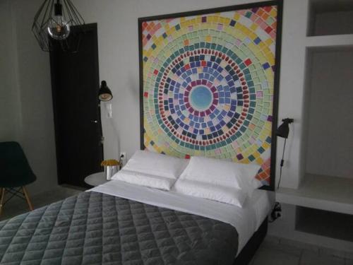 een slaapkamer met een bed met een mozaïeken hoofdeinde bij Vera studios in Heraklion