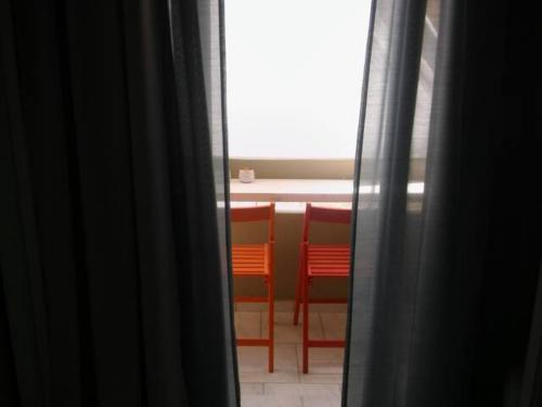 een kamer met 2 rode stoelen en een raam bij Vera studios in Heraklion