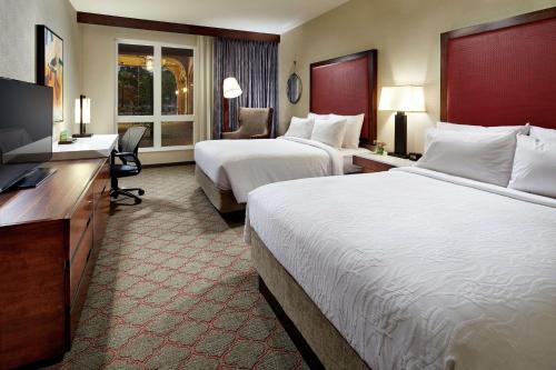 a hotel room with two beds and a flat screen tv at Hilton Garden Inn San Diego Old Town/Sea World Area in San Diego