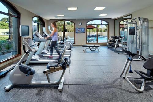 a woman walking through a gym with cardio equipment at Hilton Garden Inn San Diego Old Town/Sea World Area in San Diego
