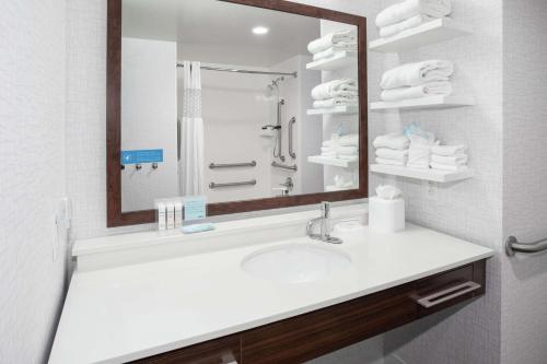 W łazience znajduje się umywalka, lustro i ręczniki. w obiekcie Hampton Inn Lincoln Airport, Ne w mieście Lincoln