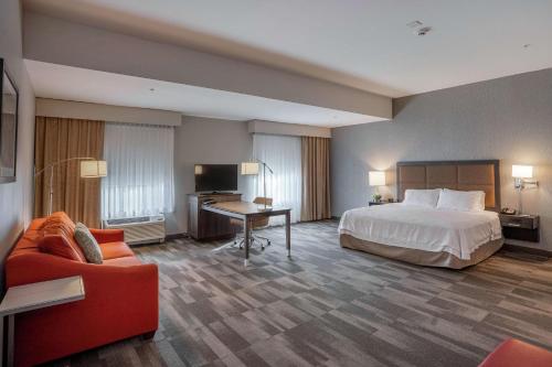 Hampton Inn and Suites Georgetown/Austin North, TX في جورج تاون: غرفه فندقيه بسرير واريكه