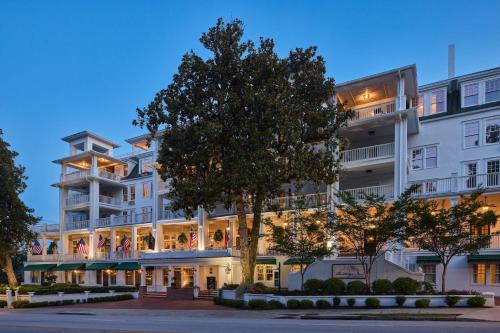 a large white building with a tree in front of it at The Partridge Inn Augusta, Curio Collection by Hilton in Augusta