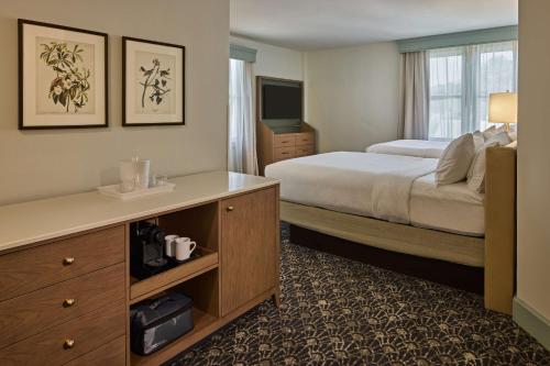 a hotel room with a bed and a desk and a television at The Partridge Inn Augusta, Curio Collection by Hilton in Augusta
