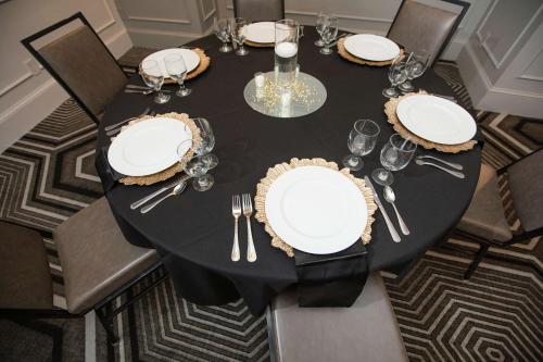 a black table with white plates and silverware on it at The Partridge Inn Augusta, Curio Collection by Hilton in Augusta