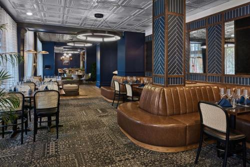 a restaurant with a leather couch and tables and chairs at The Partridge Inn Augusta, Curio Collection by Hilton in Augusta