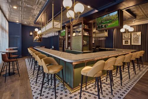 a bar in a restaurant with stools and a counter at The Partridge Inn Augusta, Curio Collection by Hilton in Augusta