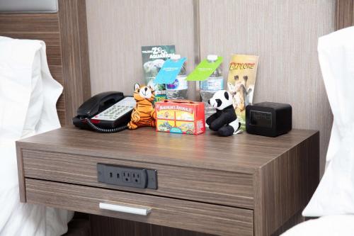 a nightstand with a phone and stuffed animals on it at Hampton Inn Toledo Oregon in Oregon