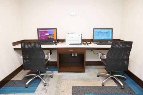an office with two computers on a desk with two chairs at Hampton Inn Toledo Oregon in Oregon