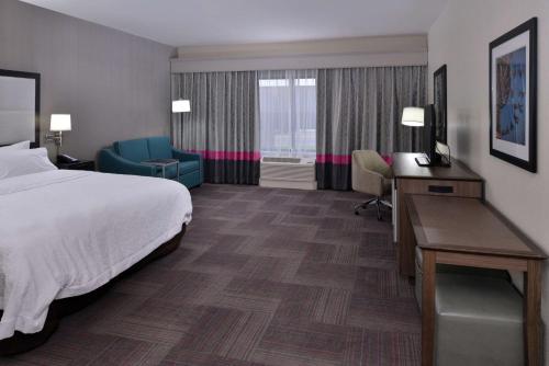 レブンワースにあるHampton Inn Leavenworthのベッド、デスク、椅子が備わるホテルルームです。