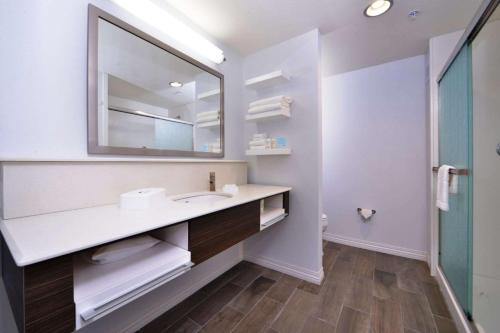 W łazience znajduje się umywalka i lustro. w obiekcie Hampton Inn Leavenworth w mieście Leavenworth