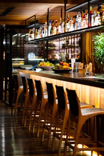 a bar with a row of chairs in a restaurant at Zendaya Resort Beach Sport & Spa in Búzios