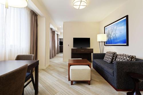 a living room with a couch and a tv at Homewood Suites by Hilton Richmond-Downtown in Richmond