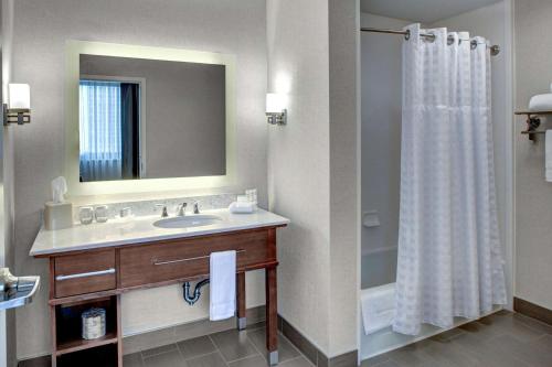 里士滿的住宿－里士滿市中心希爾頓惠庭套房酒店，一间带水槽和淋浴帘的浴室