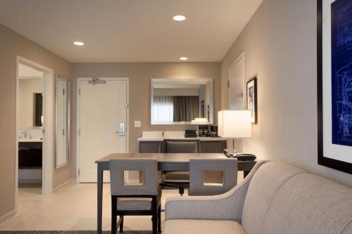 a living room and kitchen with a table and chairs at Embassy Suites by Hilton Kansas City Olathe in Olathe