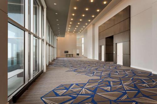 a hallway in a building with a tile floor and windows at Embassy Suites by Hilton Kansas City Olathe in Olathe