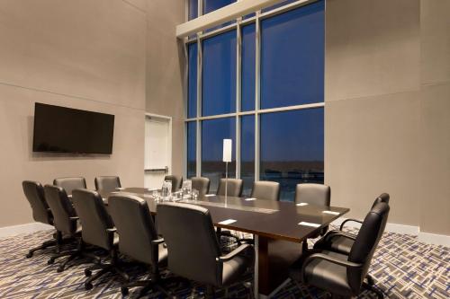 a conference room with a table and chairs and a large window at Embassy Suites by Hilton Kansas City Olathe in Olathe