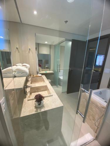 a bathroom with two sinks and a bath tub at Golden Tulip São José dos Campos in São José dos Campos