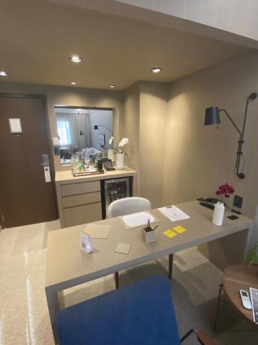 a room with a table and chairs and a kitchen at Golden Tulip São José dos Campos in São José dos Campos