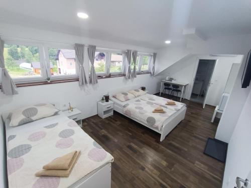 2 camas en una habitación blanca con ventanas en House Mesić, en Smoljanac