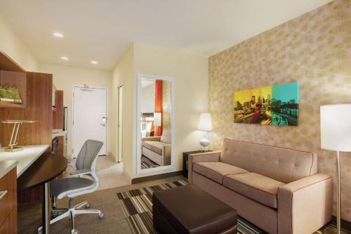 a living room with a couch and a desk at Home2 Suites by Hilton Minneapolis Bloomington in Bloomington