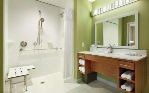 a bathroom with a sink and a shower with a mirror at Home2 Suites by Hilton Minneapolis Bloomington in Bloomington