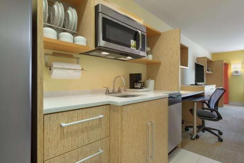 a kitchen with a sink and a tv on the wall at Home2 Suites by Hilton Atlanta South/McDonough in McDonough
