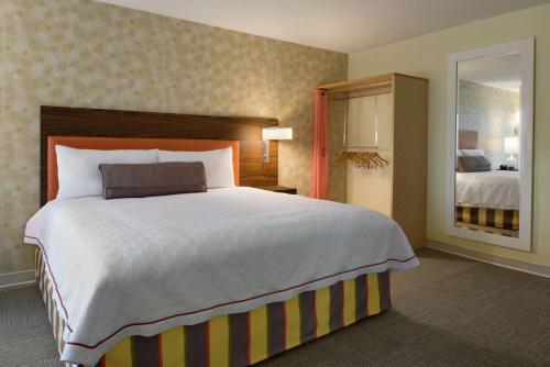 Cette chambre comprend un grand lit et un miroir. dans l'établissement Home2 Suites by Hilton Atlanta South/McDonough, à McDonough