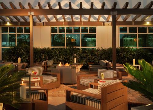 an outdoor patio with couches and tables and candles at Hilton Garden Inn Miami Dolphin Mall in Miami