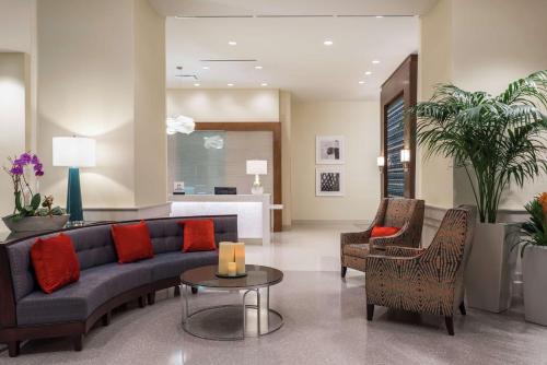 a living room with a couch and chairs and a table at Hilton Garden Inn Miami Dolphin Mall in Miami