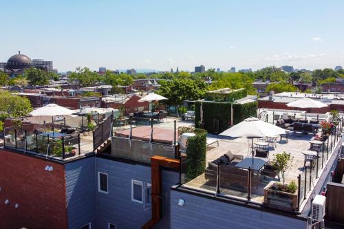 a view of a rooftop patio with tables and umbrellas at Parc Avenue Hostel in Montréal