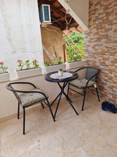 two chairs and a table on a patio at Apartmani relax in Leskovac