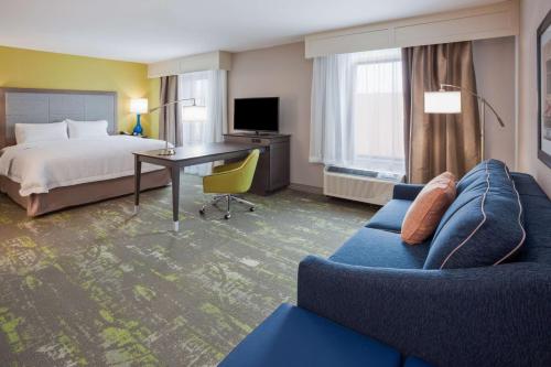 a hotel room with a bed and a desk and a couch at Hampton Inn & Suites Sioux City South, IA in Sioux City