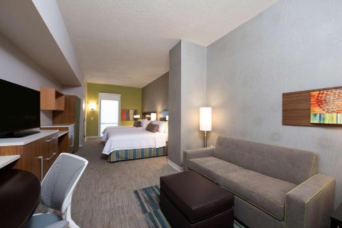 a hotel room with a bed and a couch at Home2 Suites by Hilton Indianapolis Downtown in Indianapolis