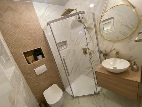 La salle de bains est pourvue d'une douche et d'un lavabo. dans l'établissement Stylish apartment with sea view, à Petrčane