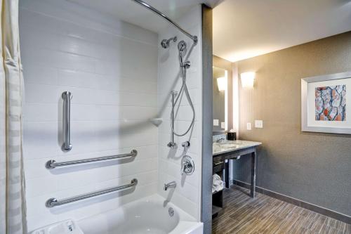 a bathroom with a tub and a shower with a sink at Homewood Suites by Hilton Nashville Franklin in Franklin