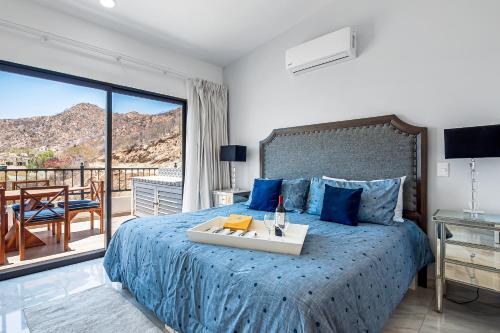 1 dormitorio con cama azul y balcón en Morgan Residences 607A en Cabo San Lucas