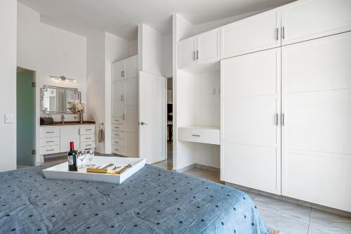 a white bedroom with a bed and white cabinets at Morgan Residences 607A in Cabo San Lucas