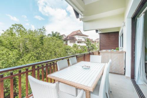 a balcony with a wooden table and chairs at Nearby beach and beach club at Portillo NF in Las Terrenas